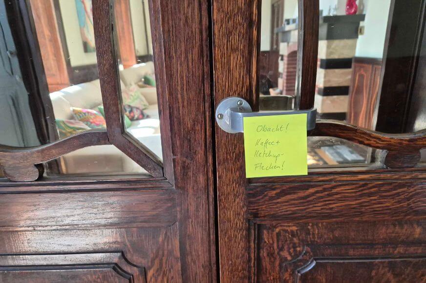 ecovacs-deebot-t90-pro-omni-testparcours-hinweis-flecken Image alt: Hinweiszettel am Türrahmen: Kaffee- und Ketchupflecken als Testparcours für den ECOVACS DEEBOT T90 PRO OMNI beim Netzwelt First Look Event.